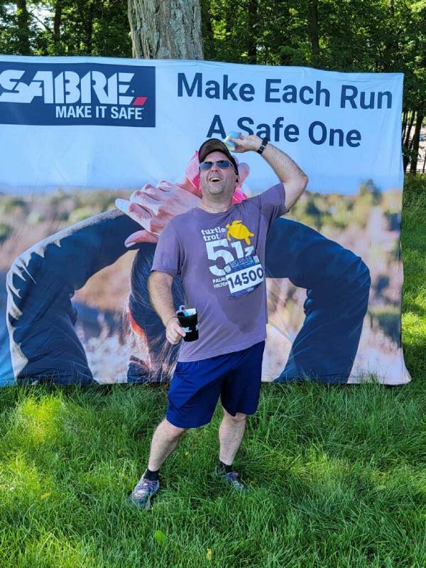 brain bolt 5k 1 person celebrating in front of poster